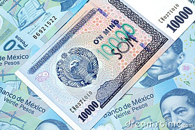 A Uzbekistan som bank note with Mexican peso bank notes Editorial Stock Photo