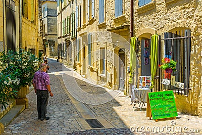 UZES, FRANCE, JUNE 20, 2017: People are strolling through a narrow street in the center of Uzes, FranceUZES, FRANCE, JUNE 20, 2017 Editorial Stock Photo