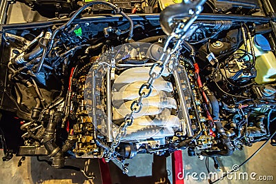 V8 engine out on hoist to get rebuilt Stock Photo