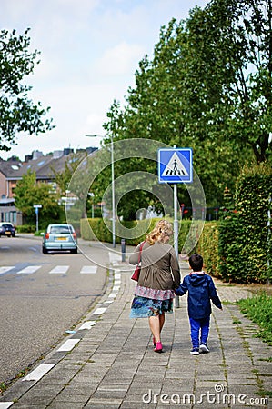 VAALS, NETHERLANDS - Aug 15, 2019: Woman and child walking on sidewalk Editorial Stock Photo