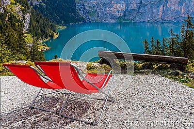 Vacant deckchairs mountain lake at summer relaxing view Stock Photo