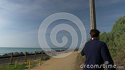 A handsome, young guy, a man in a navy blue shirt, shorts and glasses walks and spin by lantern in California coast San. Vacation in california usa summer day stock footage A handsome, young guy, a man in a navy blue shirt, shorts and glasses walks and spin by lantern in California coast San. Vacation in california usa summer day stock footage