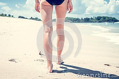 Vacation concept. Close up of female legs walking by the beach of tropical island Bali, Indonesia. Stock Photo