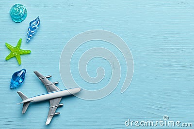 Vacation and sea flight concept with airplane and glass shells on wooden blue background with copy space Stock Photo
