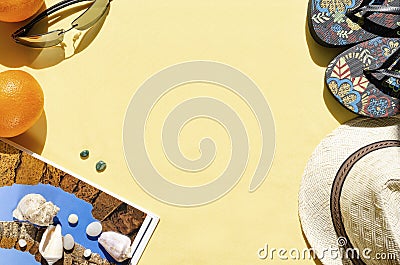 Summer background. Flat lay of straw hat, sunglasses, flip flops and seashells on yellow background. Vacation concept Stock Photo