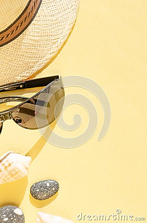 Vacation and summer holidays concept. Flat lay design of straw hat, sunglasses and seashells on yellow background Stock Photo