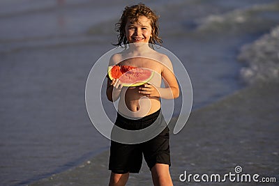 Vacation and traveling with kids. Summer watermelon fruit for children. Child play by the sea and eat watermelon. Little Stock Photo