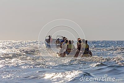 Vacationers tourists ride an inflatable banana in the sea Editorial Stock Photo