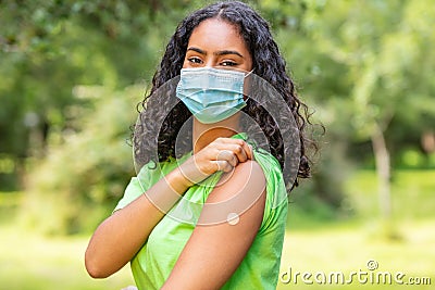 Vaccinated African American female young woman wearing face mask and vaccine band aid Stock Photo
