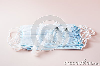 Vaccination and Immunization. Clean syringes and glass vaccine vials with face protective masks Stock Photo