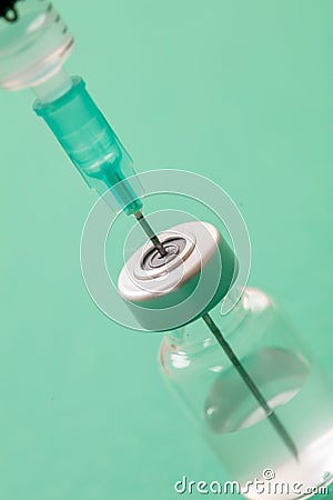 Vaccine vial dose and syringe against green background Stock Photo