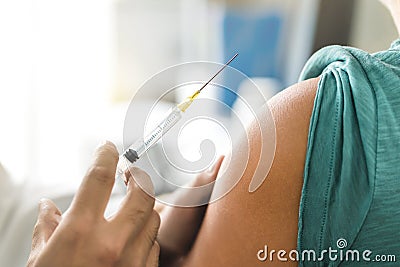 Vaccine or flu shot in injection needle. Doctor working with patient`s arma. Stock Photo