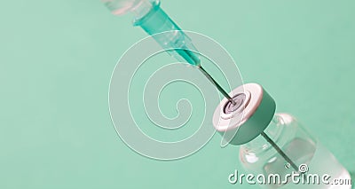 Vaccine vial dose and syringe against green background Stock Photo