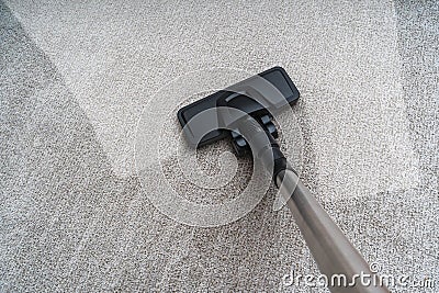 Vacuum cleaner is cleaning dirty carpet. Housework concept. Stock Photo