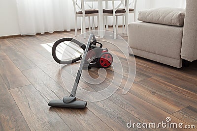 Vacuum cleaner on the wooden floor. Cleaning home Stock Photo