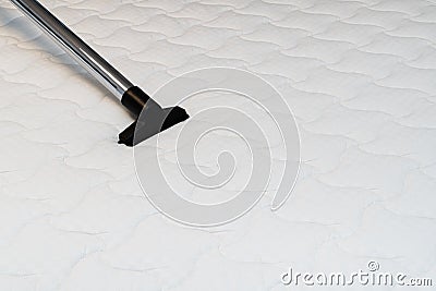 Vacuum cleaning the bed mattress. Dust removal for allergy prevention Stock Photo