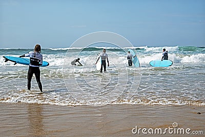 VALE FIGUEIRAS, PORTUGAL - March 29, 2022: Surfers getting surfers lessons at the atlantic ocean in Portugal Editorial Stock Photo