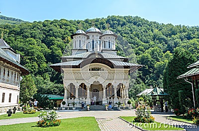 Tourists visit the old Lainici Monastery on a summer`s day, detail from the courtyard with exterior paintings Editorial Stock Photo