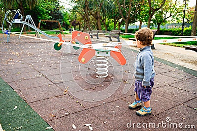 Valencia, Spain - April 26, 2020: Children observe a playground closed for health security to avoid virus infections Editorial Stock Photo