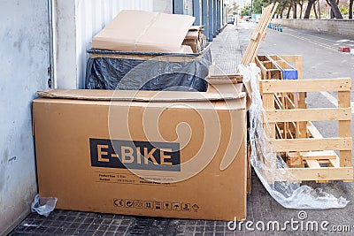 Valencia, Spain - December 28, 2021: After Christmas gifts, empty boxes accumulate as waste in the streets, box of an e-bike Editorial Stock Photo