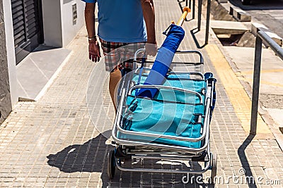 Valencia, Spain - June 23, 2019: Holiday vacationers head to the beach with inflatable chairs and mattresses to enjoy summer Editorial Stock Photo