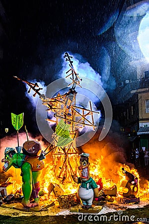 Valencia, Spain - March 19, 2019: Detail of a Falla Valenciana burning between flames of fire Editorial Stock Photo