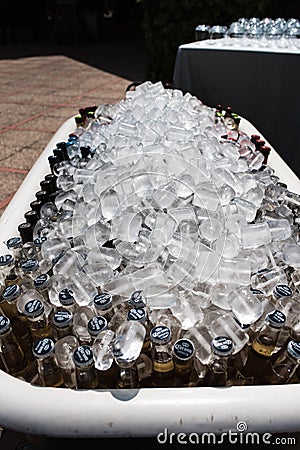Valencia, Spain - September 28, 2021: Bottles of beers and soft drinks inside a barrel with ice to cool it down Editorial Stock Photo