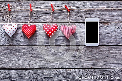 Valentine day background, pillow hearts and smartphone on wood Stock Photo