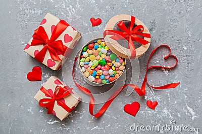 Valentine day composition: sweet candy, with gift boxes with bow and red felt hearts, photo template, background. Top Stock Photo