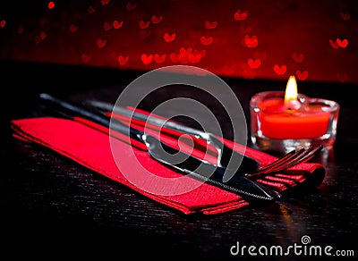 Valentine day table setting with knife, fork, red burning heart shaped candle Stock Photo