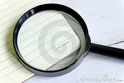 Valentine day theme. LOVE FOREVER words on a book with magnifying glass Stock Photo
