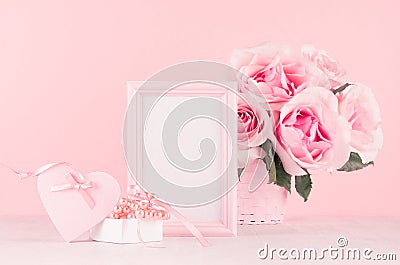 Valentine days decor for home in soft pastel pink - romance bouquet of roses, heart, gift box with perls, ribbon and blank frame. Stock Photo