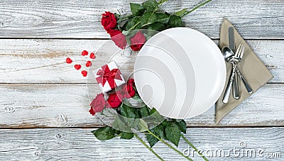Valentine dinner setting with flowers and gift on white table Stock Photo