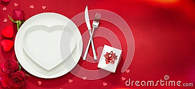 Plate, fork, knife and roses on red cover Stock Photo