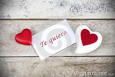 Valentine greeting card on wooden table with text written in spanish Te quiero, which means I love you. Stock Photo