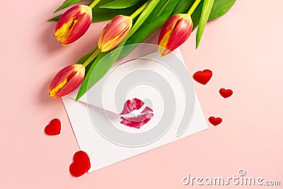 Valentine`s day background. Envelope with red lipstick kiss, hearts and tulips on pink. Stock Photo