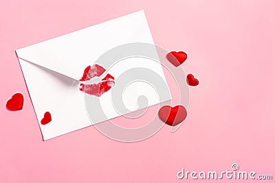 Valentine`s day background. Envelope with red lipstick kiss and hearts on pink. Stock Photo