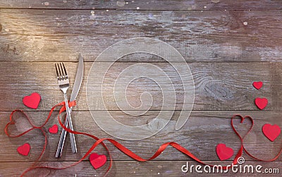 Red strips fork and knife on wooden table Stock Photo
