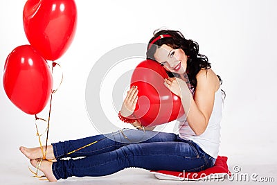 Valentine's day beautiful young woman wearing red dress and holding red balloons Stock Photo