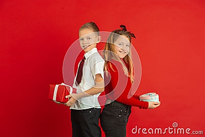 Valentine`s day celebration, happy caucasian kids isolated on red background Stock Photo