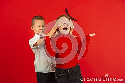 Valentine`s day celebration, happy caucasian kids isolated on red background Stock Photo