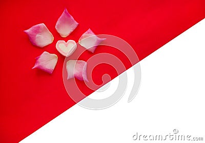 Valentine`s Day concept with heart shaped marshmallows and pink rose petals on red paper and white background Stock Photo
