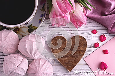 Valentine`s day elegant still life with tulip flowers cup of coffe marshmallow red heart shape sign on white wooden background Stock Photo