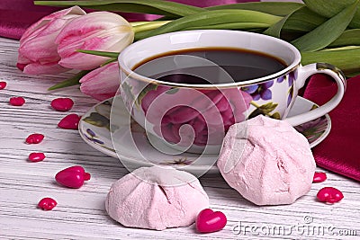 Valentine`s day elegant still life with tulip flowers cup of coffe marshmallow red heart shape sign on white wooden background Stock Photo