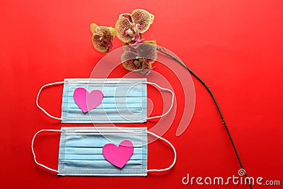 Valentine`s Day gifts in pandemic by covid-19, picture holder and flowers with protection mask for clinical use and pink hearts Stock Photo