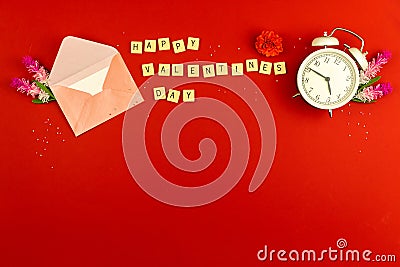 Valentine\'s day greeting card concept, red background, envelop and morning alarm clock, flowers, love theme, word on cubes Stock Photo