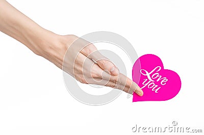 Valentine's Day and love theme: hand holds a greeting card in the form of a pink heart with the words Love you isolated Stock Photo