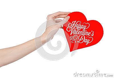 Valentine's Day and love theme: hand holds a greeting card in the form of a red heart with the words Happy Valentine's day Stock Photo