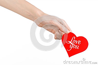 Valentine's Day and love theme: hand holds a greeting card in the form of a red heart with the words Love you isolated Stock Photo