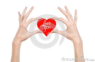 Valentine's Day and love theme: hand holds a greeting card in the form of a red heart with the words Love you isolated Stock Photo